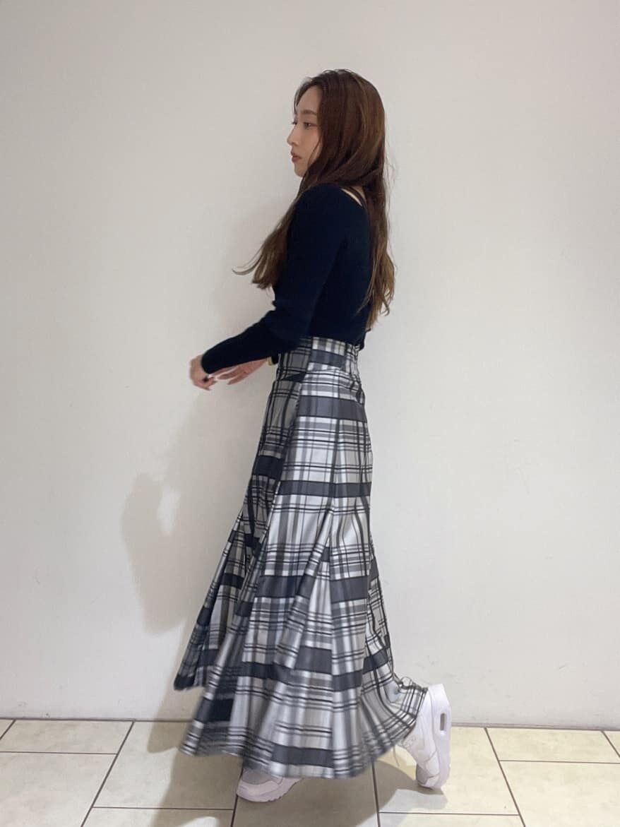 ブラック系のニット/セーター、ホワイト系のスニーカー、ブラック系のスカートを着用したレディースの秋コーディネートの2枚目の写真