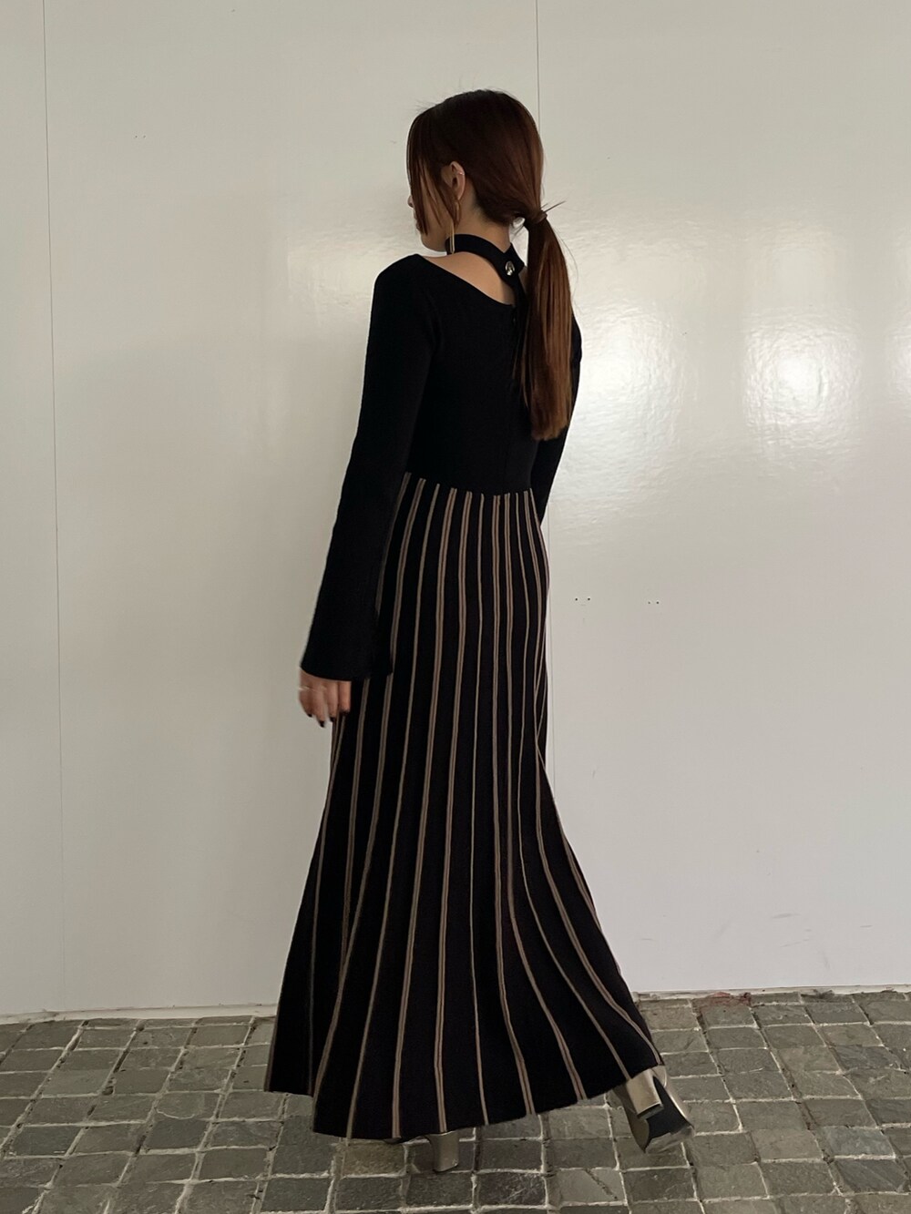 ブラック系のワンピース、シルバー系のブーツを着用したレディースの冬コーディネートの4枚目の写真