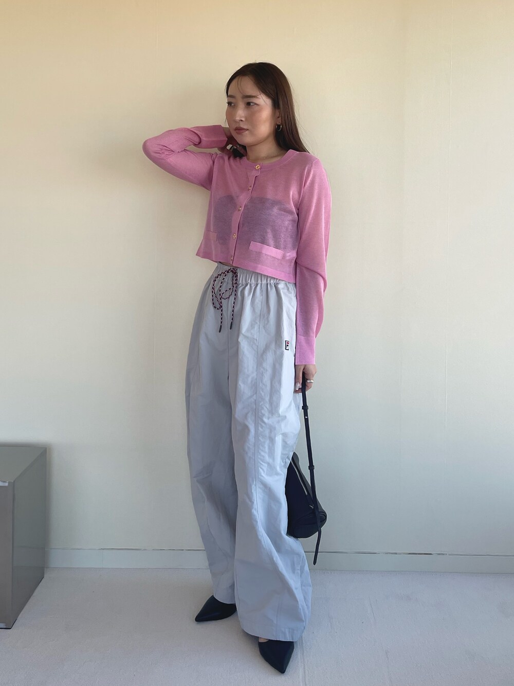 ピンク系のカーディガン/ボレロ、ベージュ系のその他パンツ、ブラック系のパンプスを着用したレディースの冬コーディネートの2枚目の写真