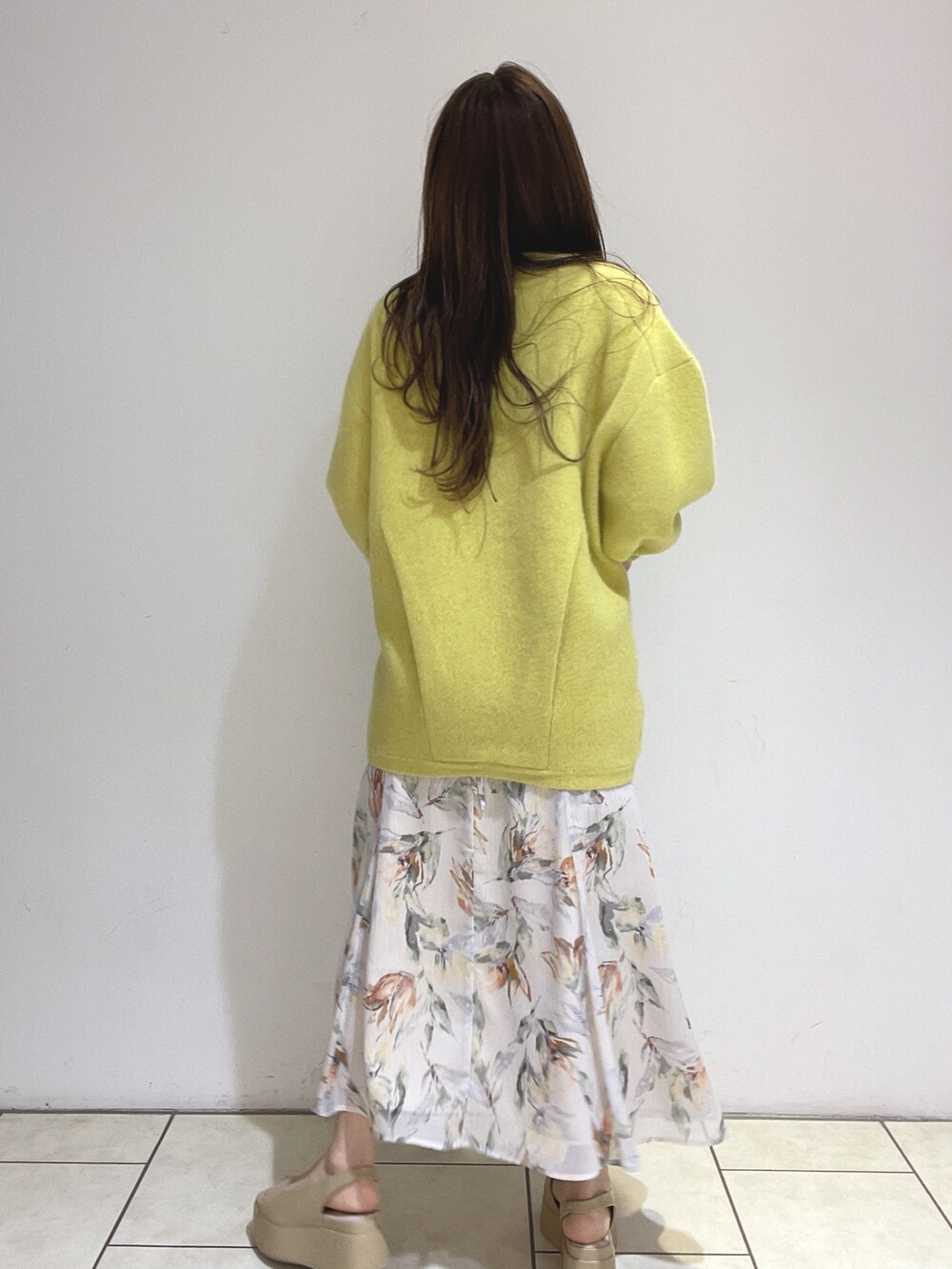 ホワイト系のワンピース、イエロー系のカーディガン/ボレロ、ベージュ系のサンダルを着用したレディースの冬コーディネートの7枚目の写真