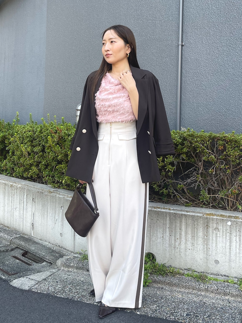 ブラウン系のハンドバッグ、ピンク系のシャツ/ブラウス、ブラック系のパンプスを着用したレディースの冬コーディネートの2枚目の写真