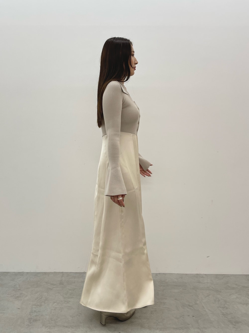 シルバー系のブーツ、ベージュ系のワンピースを着用したレディースの秋コーディネートの3枚目の写真