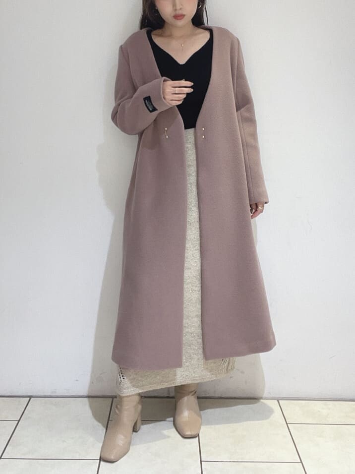 ベージュ系のブーツ、ピンク系のノーカラーコート、ブラック系のニット/セーターを着用したレディースの秋コーディネートの3枚目の写真