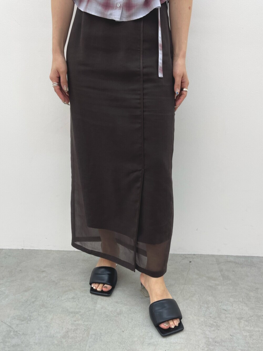 ブラウン系のスカート、ブラック系のサンダル、ピンク系のシャツ/ブラウスを着用したレディースの春コーディネートの6枚目の写真