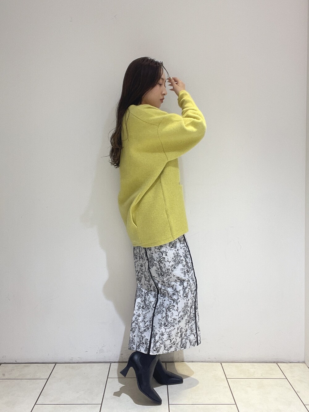 イエロー系のカーディガン/ボレロ、ブラック系のスカート、ホワイト系のニット/セーターを着用したレディースの秋コーディネートの4枚目の写真