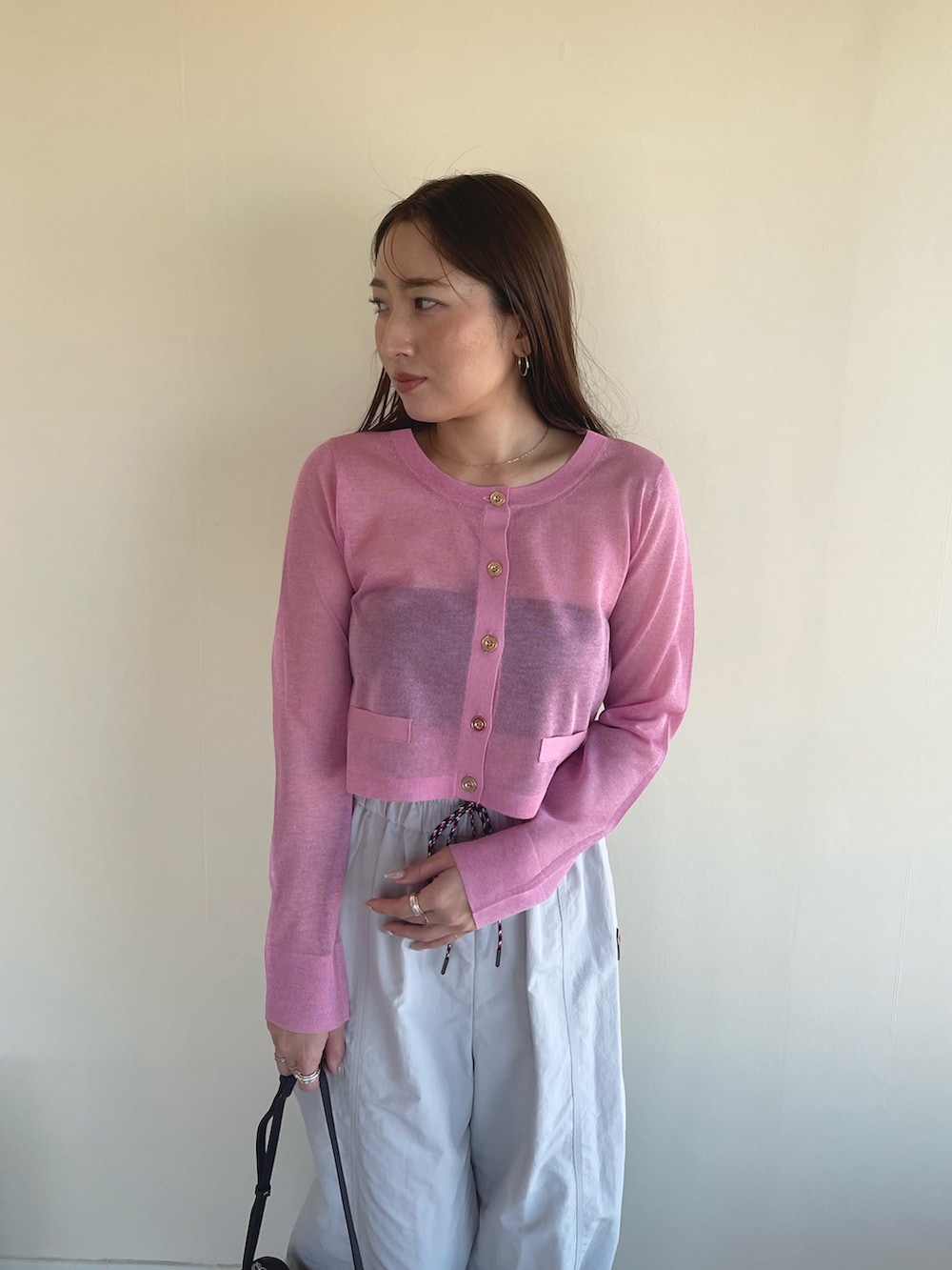 ピンク系のカーディガン/ボレロ、ベージュ系のその他パンツ、ブラック系のパンプスを着用したレディースの冬コーディネートの6枚目の写真