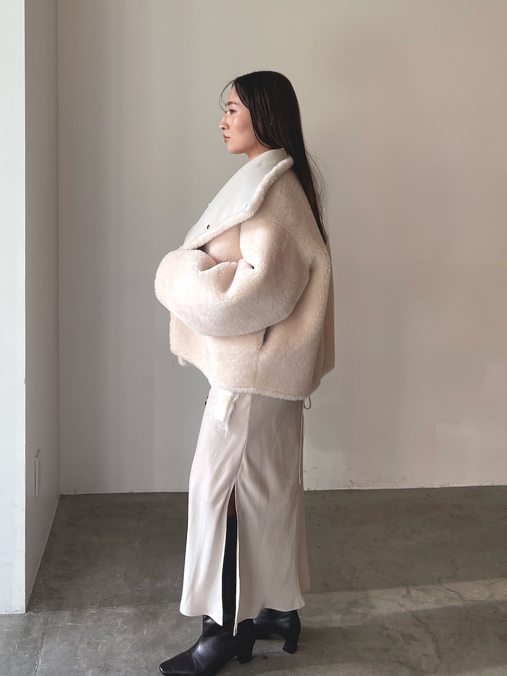 ベージュ系のワンピース、ブラウン系のハンドバッグ、ブラウン系のブーツを着用したレディースの冬コーディネートの4枚目の写真