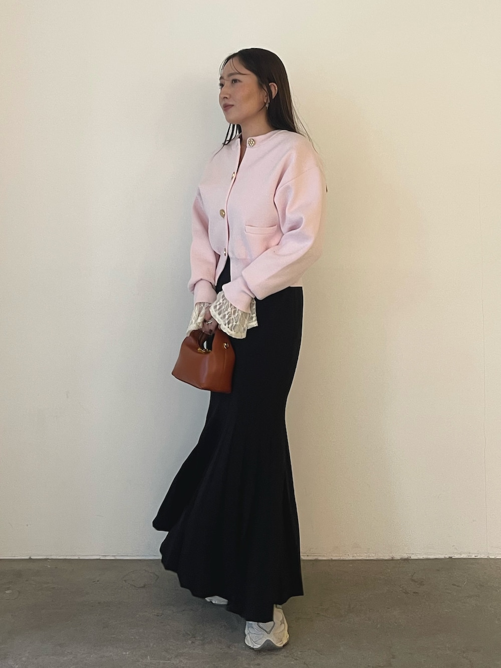 ピンク系のカーディガン/ボレロ、ホワイト系のシャツ/ブラウス、ブラウン系のハンドバッグを着用したレディースの冬コーディネートの5枚目の写真