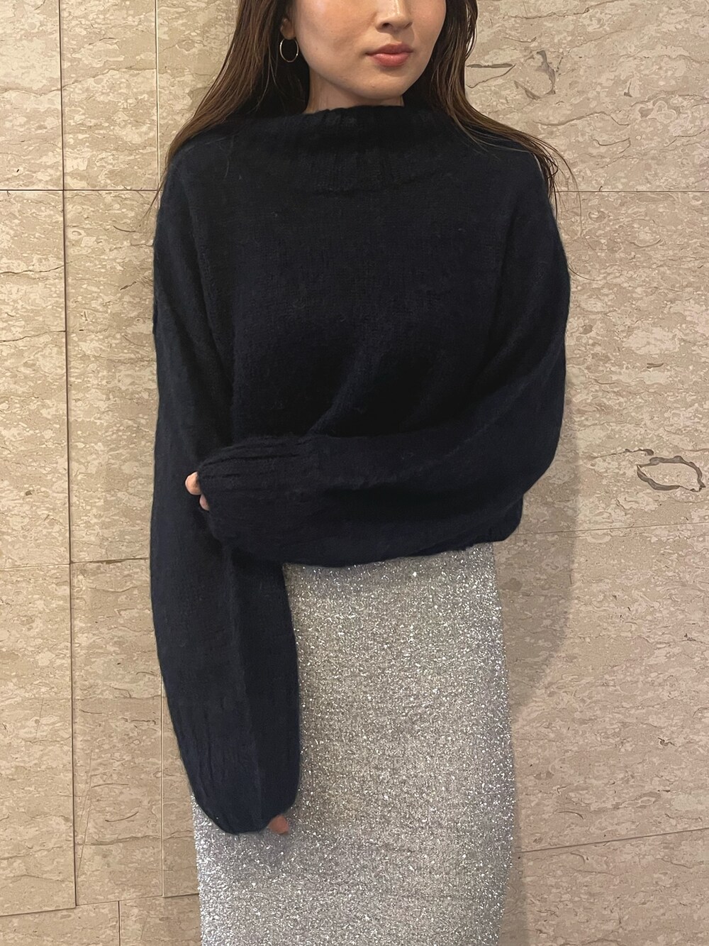 ブラック系のブーツ、ブルー系のニット/セーター、シルバー系のスカートを着用したレディースの冬コーディネートの8枚目の写真