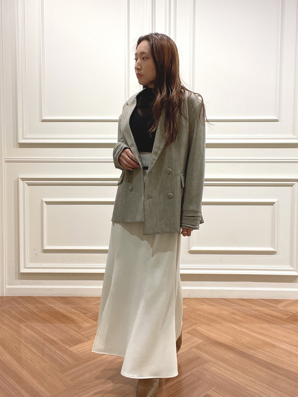 ホワイト系のスカート、ベージュ系のテーラードジャケット、ブラック系のニット/セーターを着用したレディースの秋コーディネートの5枚目の写真