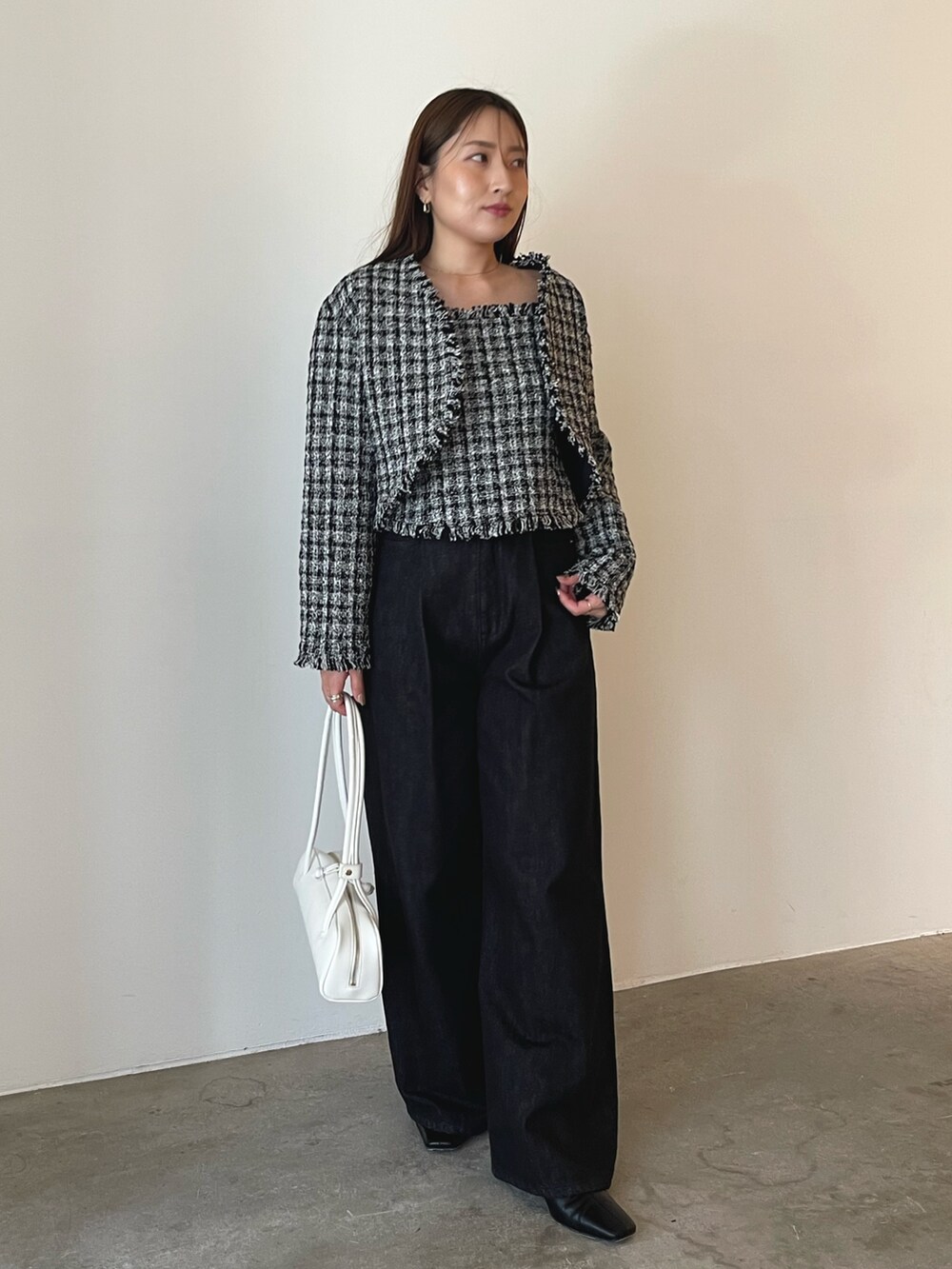 ホワイト系のショルダーバッグ、ブラック系のキャミソール、ブラック系のテーラードジャケットを着用したレディースの秋コーディネートの5枚目の写真