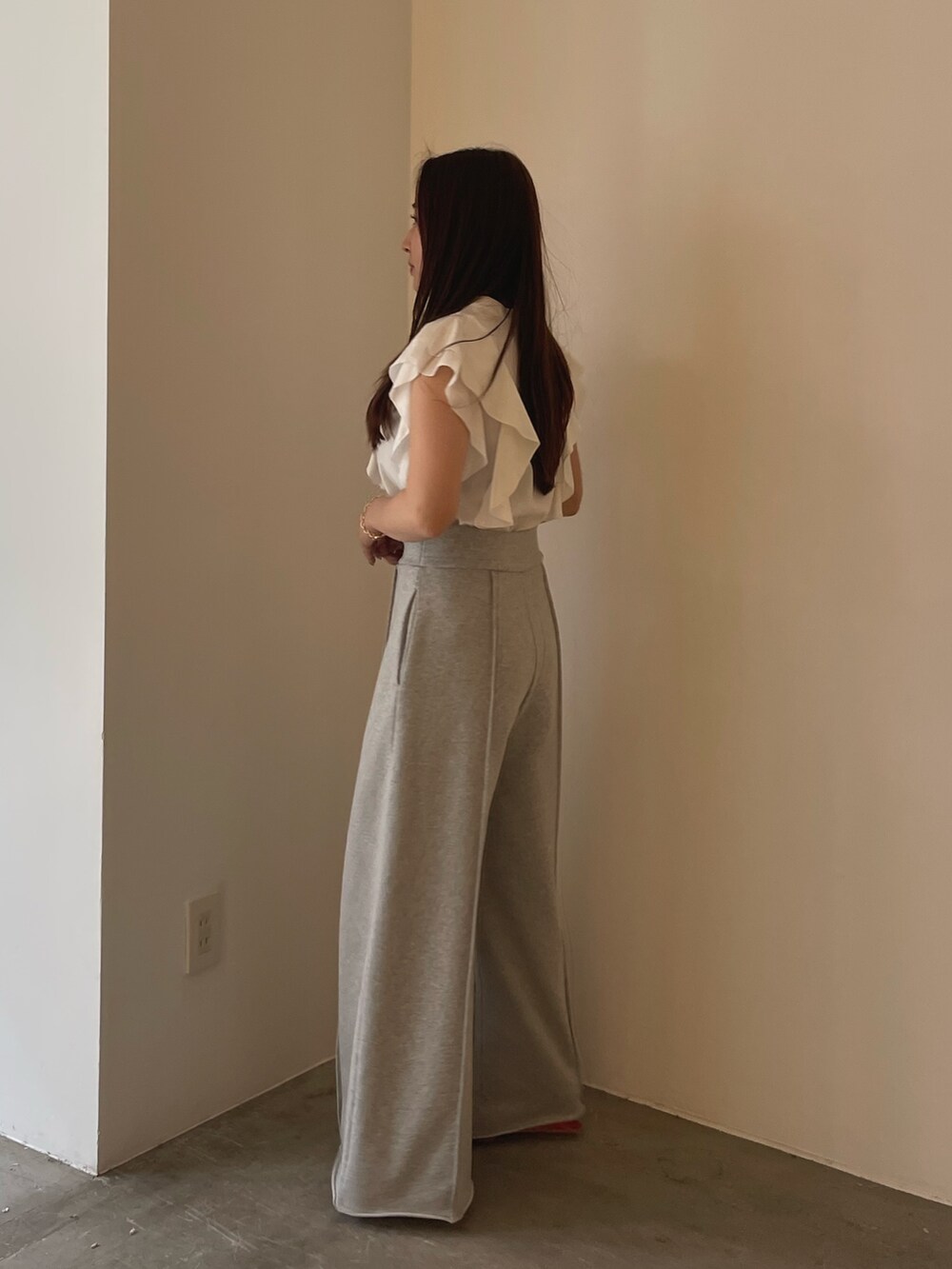 レッド系のサンダル、ホワイト系のシャツ/ブラウス、グレー系のスウェットパンツを着用したレディースの春コーディネートの6枚目の写真