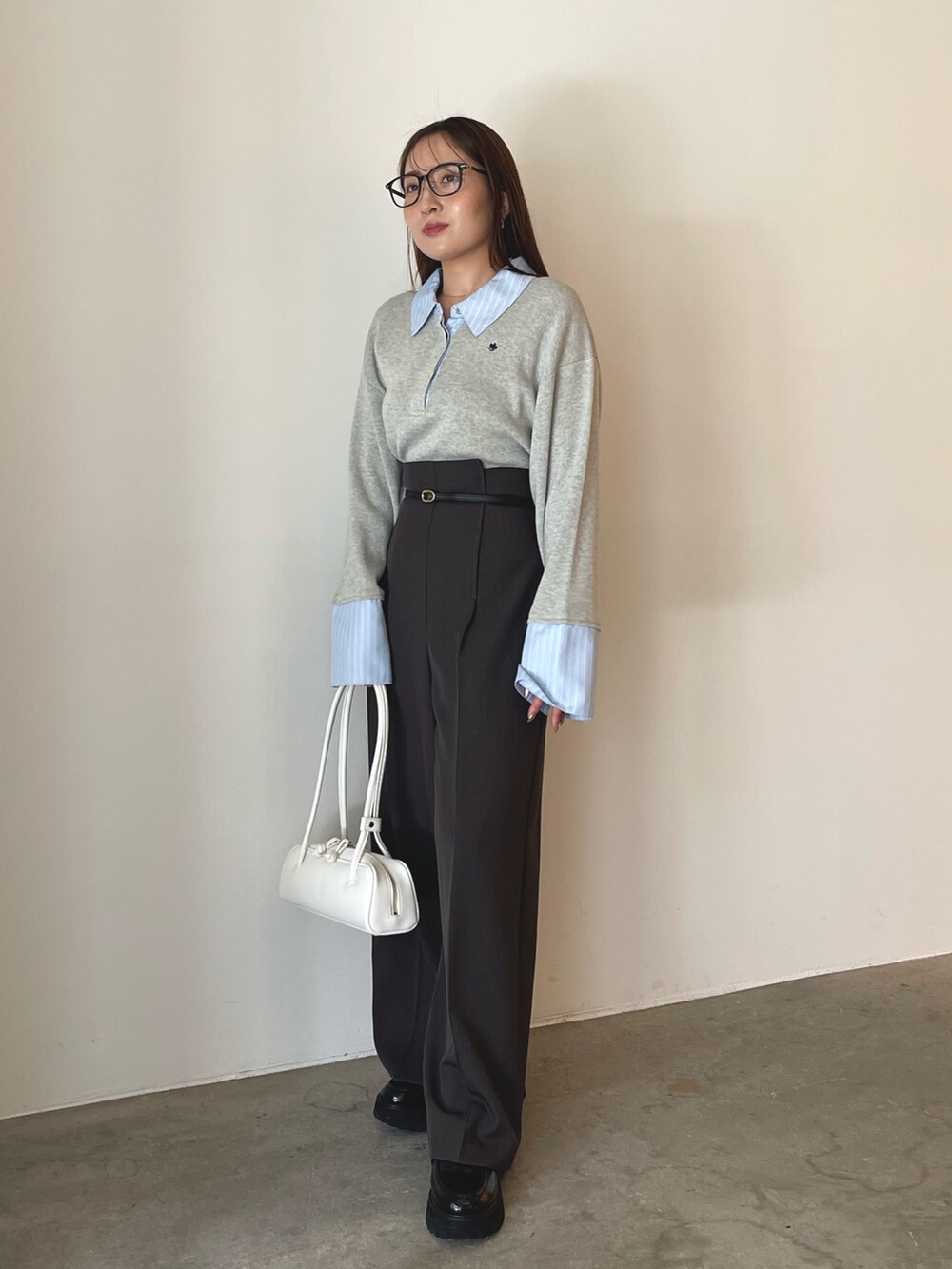 グレー系のニット/セーター、グレー系のその他パンツ、ゴールド系のピアス(両耳用)を着用したレディースの夏コーディネートの2枚目の写真