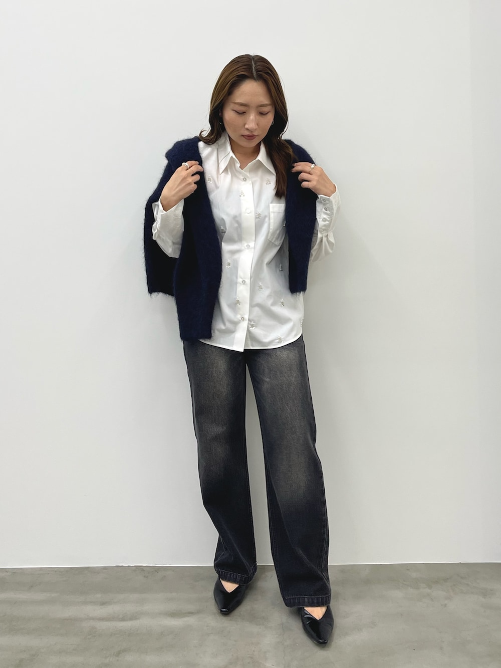 グレー系のデニムパンツ、ホワイト系のシャツ/ブラウス、ブルー系のカーディガン/ボレロを着用したレディースの秋コーディネートの2枚目の写真