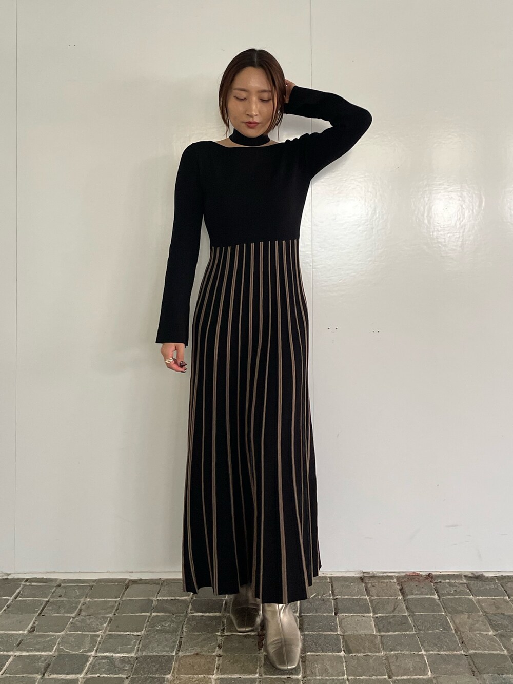 ブラック系のワンピース、シルバー系のブーツを着用したレディースの冬コーディネートの3枚目の写真