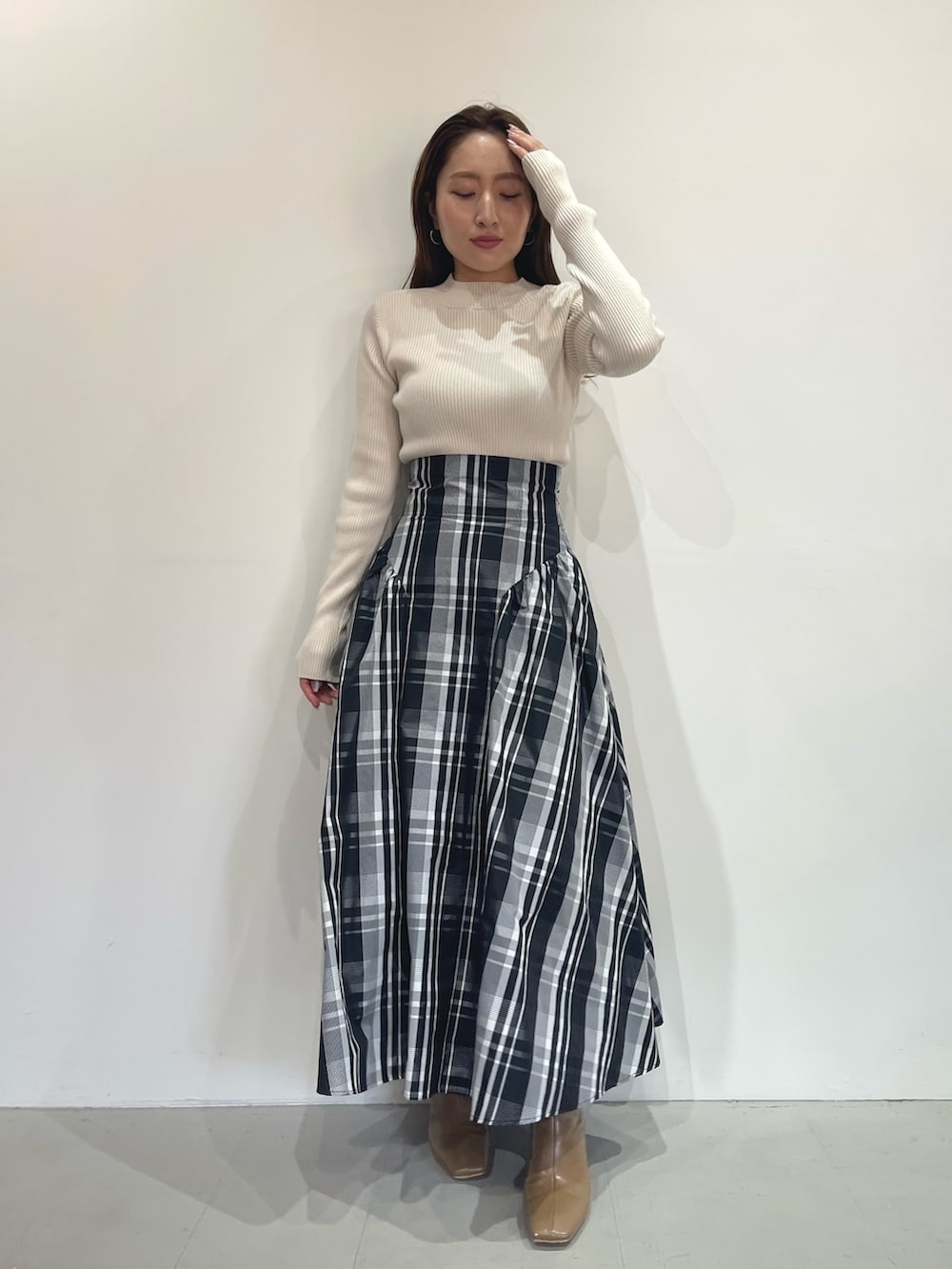 ベージュ系のブーツ、ホワイト系のニット/セーター、ホワイト系のスカートを着用したレディースの秋コーディネートの9枚目の写真