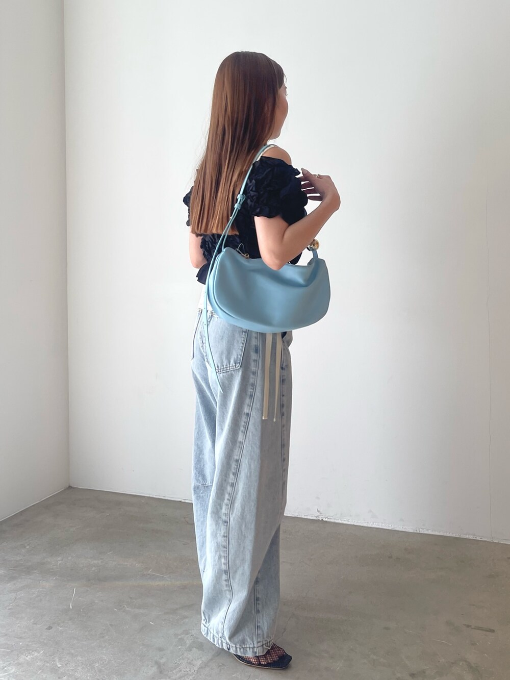 ブラック系のパンツドレス、ブルー系のデニムパンツ、ホワイト系のシャツ/ブラウスを着用したレディースの春コーディネートの5枚目の写真