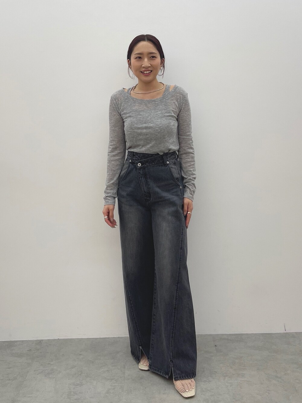 ブラック系のデニムパンツ、ホワイト系のサンダル、グレー系のTシャツ/カットソーを着用したレディースの春コーディネートの2枚目の写真