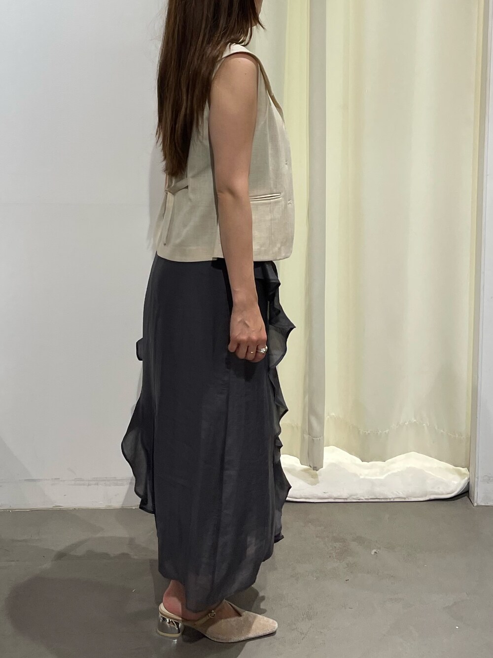 ホワイト系のベスト、グレー系のワンピース、ベージュ系のパンプスを着用したレディースの夏コーディネートの7枚目の写真