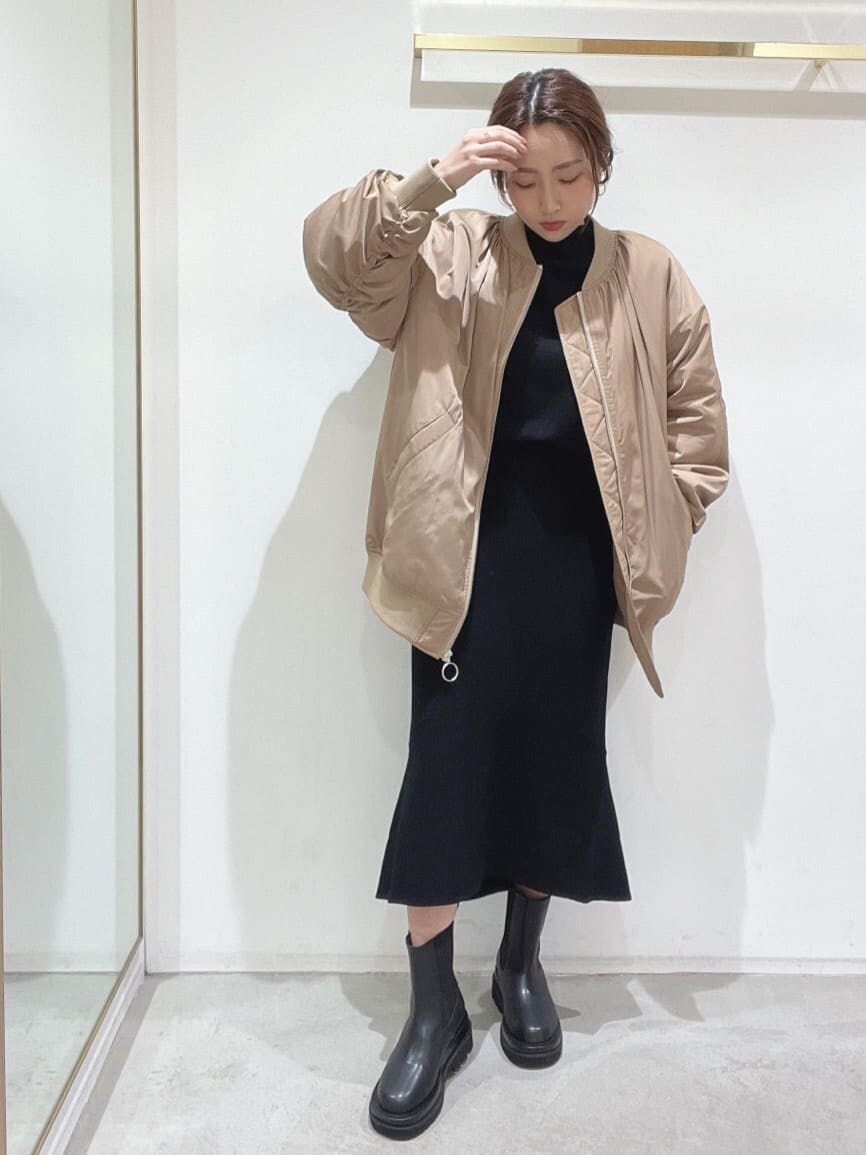 ブラック系のブーツ、ブラック系のニット/セーター、ブラック系のスカートを着用したレディースの秋コーディネートの3枚目の写真