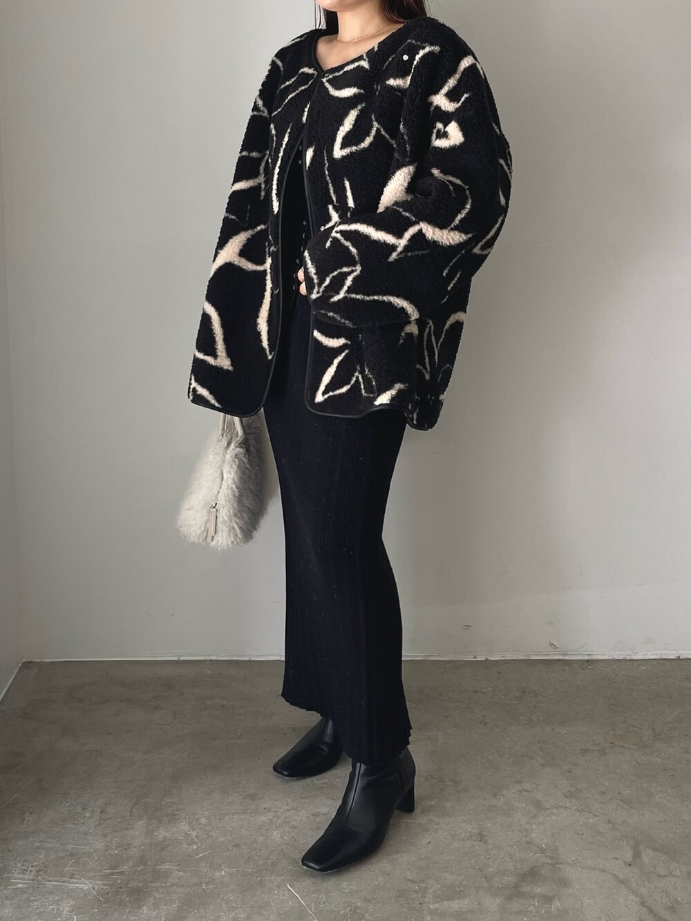 ブラック系のブーツ、ホワイト系のボストンバッグ、ブラック系のブルゾンを着用したレディースの秋コーディネートの4枚目の写真