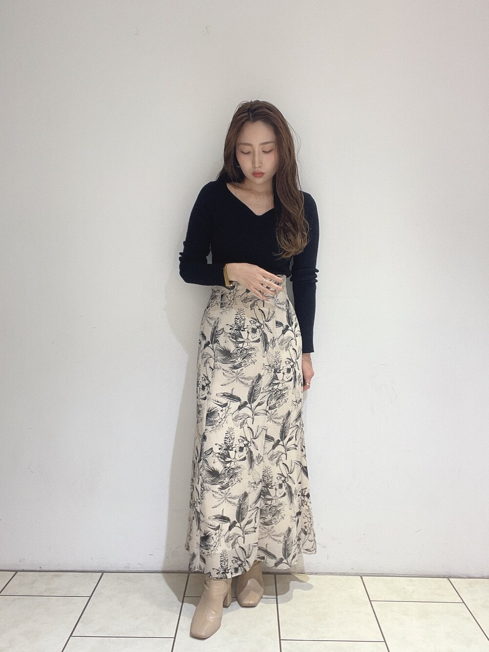 ベージュ系のスカート、ブラック系のニット/セーターを着用したレディースの秋コーディネートの4枚目の写真