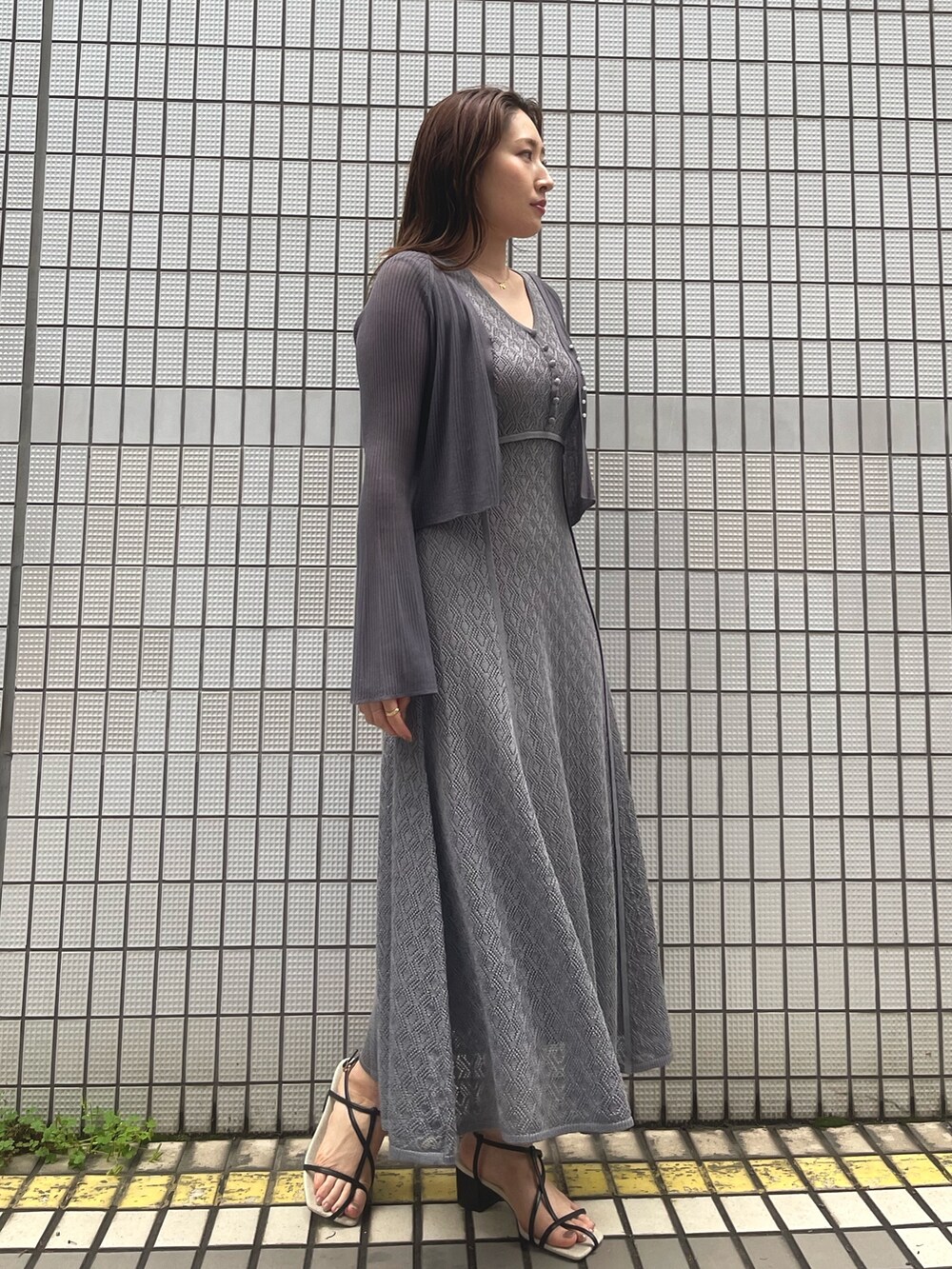 グレー系のワンピース、ブラック系のサンダル、グレー系のカーディガン/ボレロを着用したレディースの春コーディネートの3枚目の写真