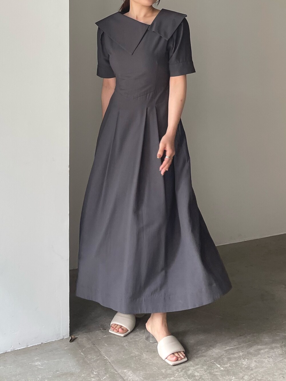 ホワイト系のサンダル、グレー系のワンピース、ゴールド系のピアス（両耳用）を着用したレディースの春コーディネートの6枚目の写真