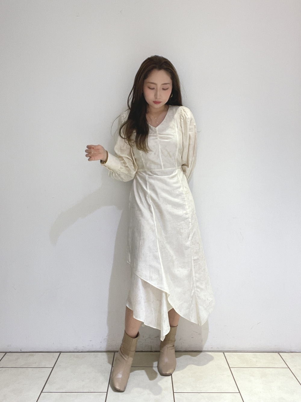 ベージュ系のブーツ、ホワイト系のワンピースを着用したレディースの冬コーディネートの9枚目の写真