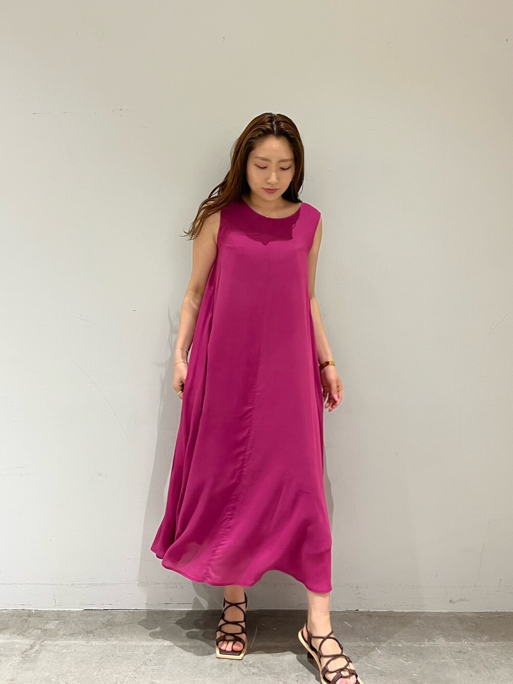 パープル系のワンピース、ブラウン系のサンダルを着用したレディースの夏コーディネートの2枚目の写真