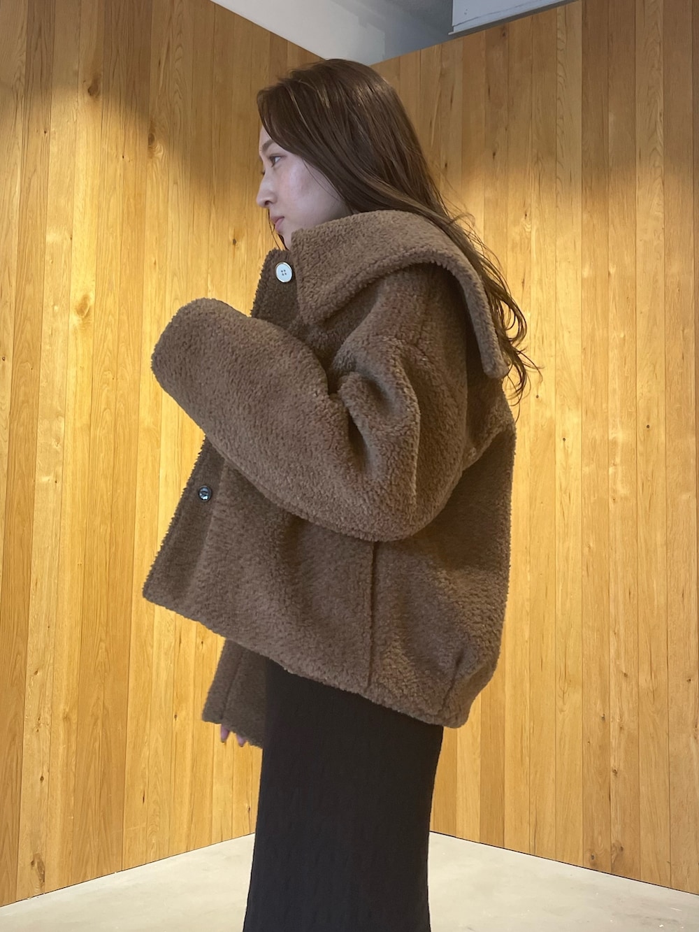 ブラウン系のブルゾン、レッド系のブーツ、ブラック系のワンピースを着用したレディースの秋コーディネートの3枚目の写真