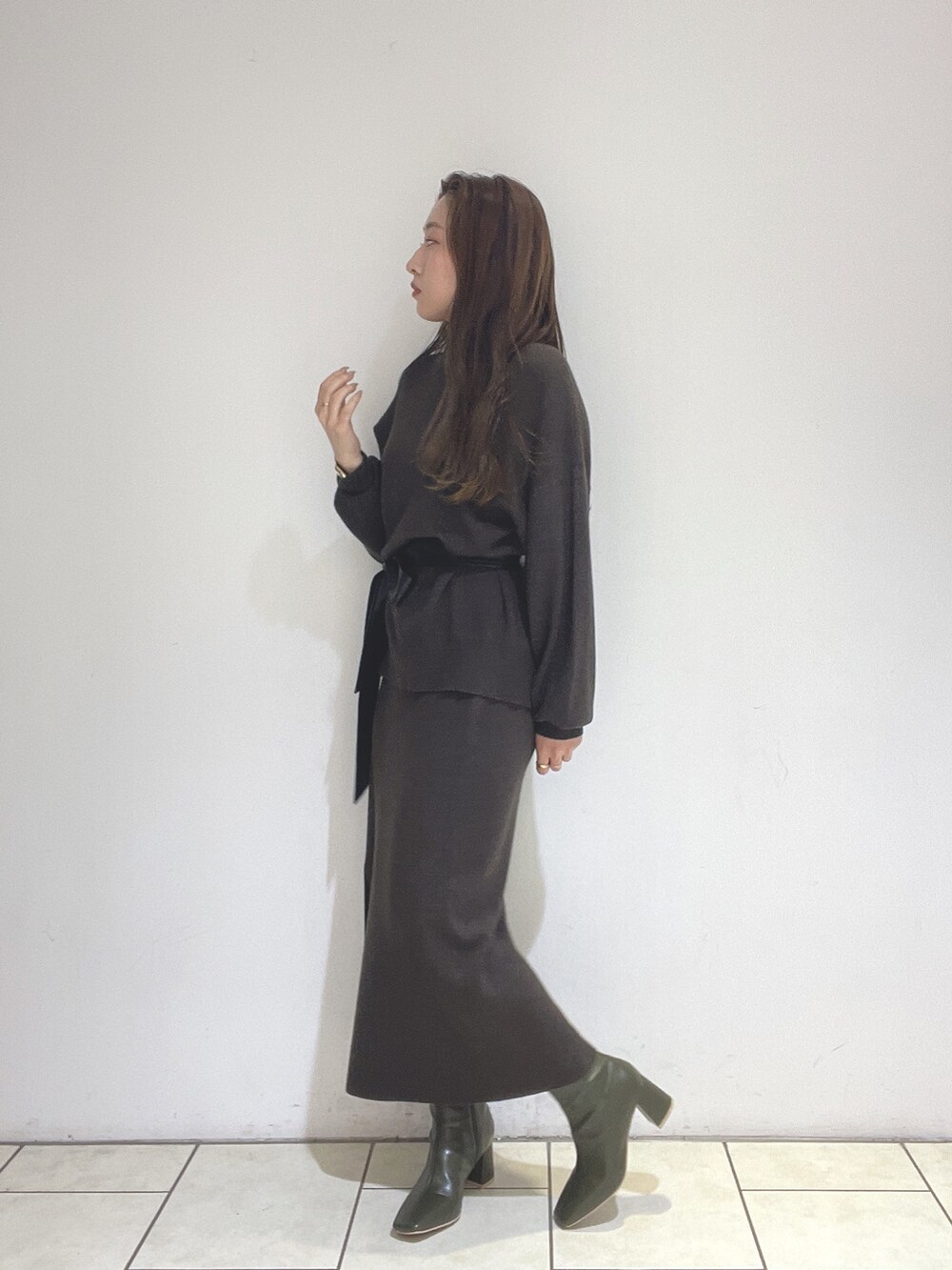 ブラウン系のニット/セーター、ブラウン系のスカート、グリーン系のブーツを着用したレディースの冬コーディネートの4枚目の写真