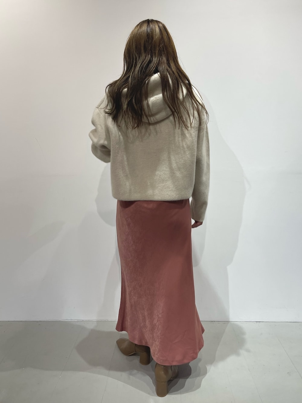 ピンク系のスカート、ベージュ系のブーツ、ホワイト系のパーカーを着用したレディースの夏コーディネートの4枚目の写真