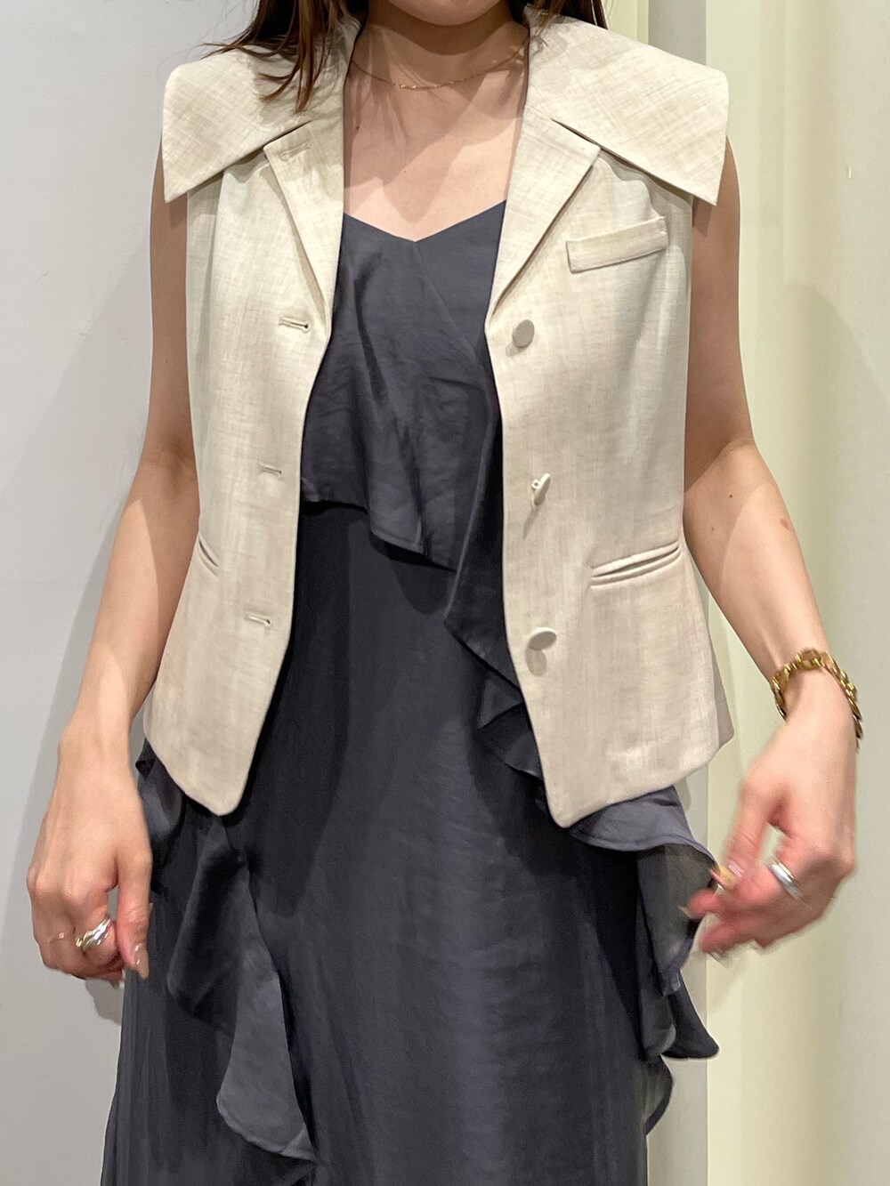 ホワイト系のベスト、グレー系のワンピース、ベージュ系のパンプスを着用したレディースの夏コーディネートの10枚目の写真