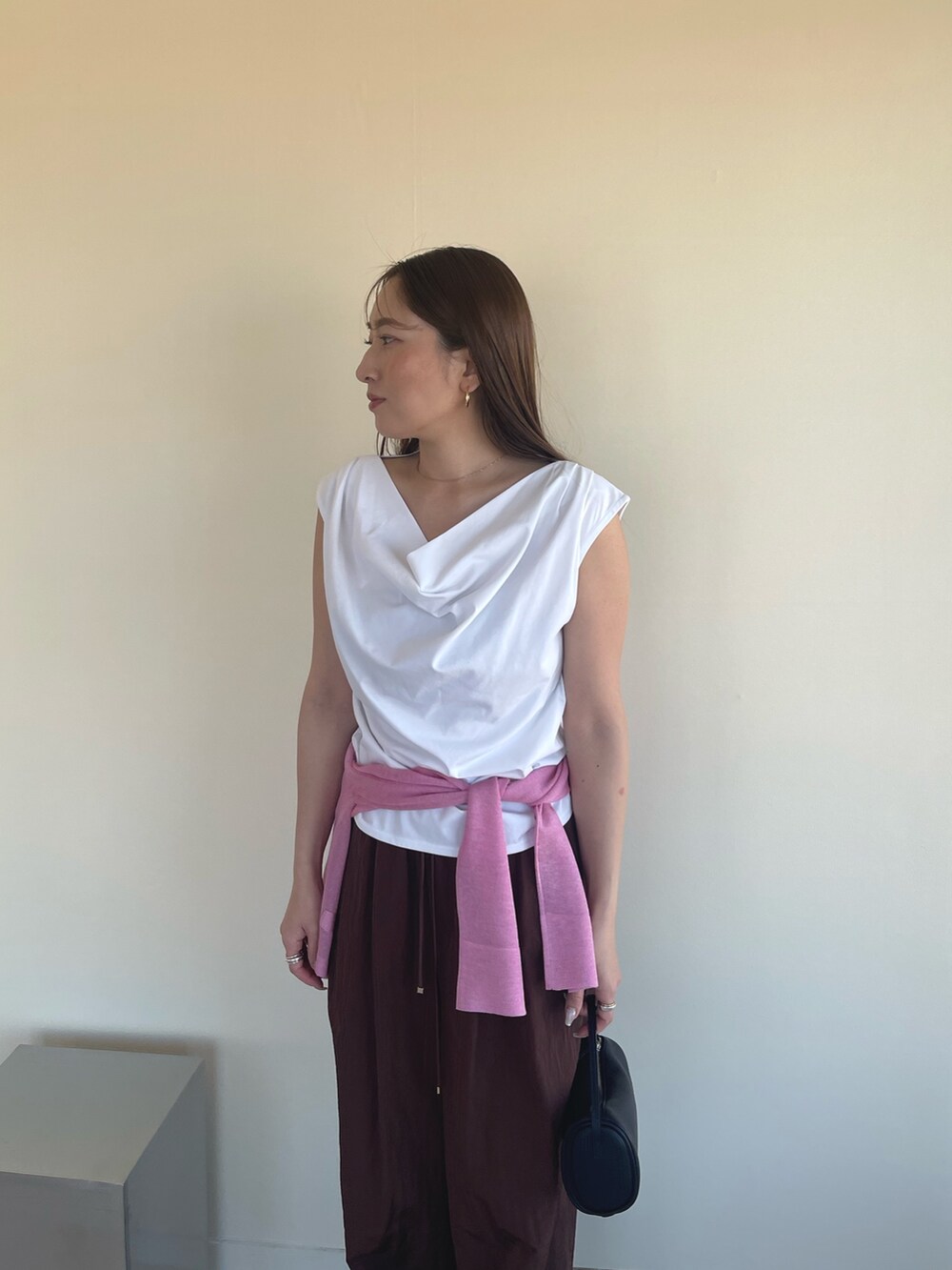 ホワイト系のTシャツ/カットソー、ピンク系のカーディガン/ボレロ、ブラック系のパンプスを着用したレディースの春コーディネートの6枚目の写真