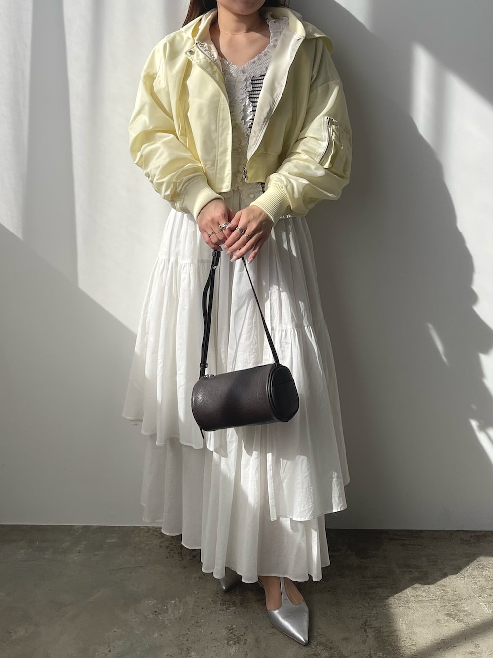 その他のニット/セーター、イエロー系のブルゾン、ホワイト系のスカートを着用したレディースの春コーディネートの9枚目の写真
