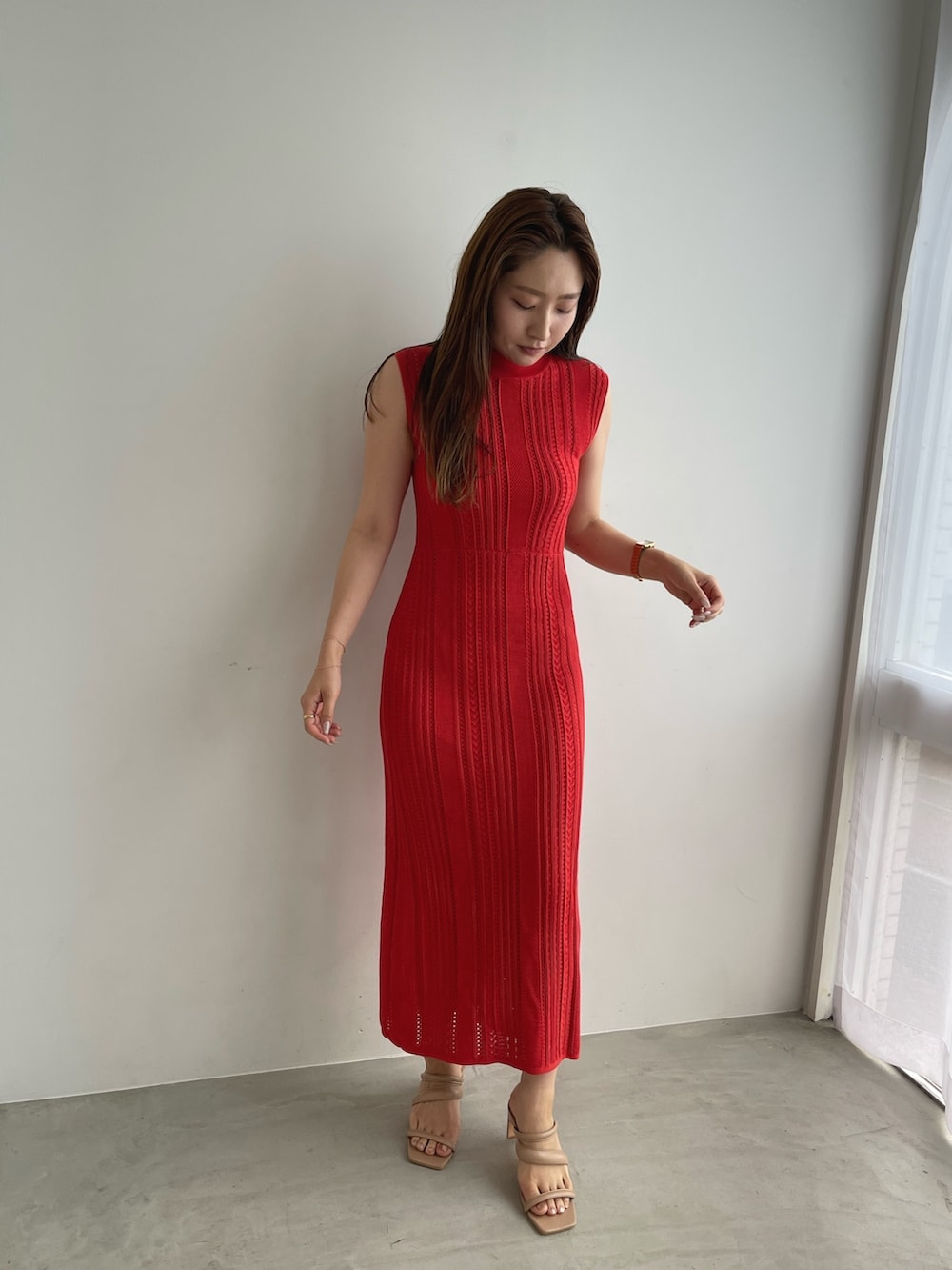 レッド系のワンピース、ベージュ系のサンダルを着用したレディースの夏コーディネートの3枚目の写真