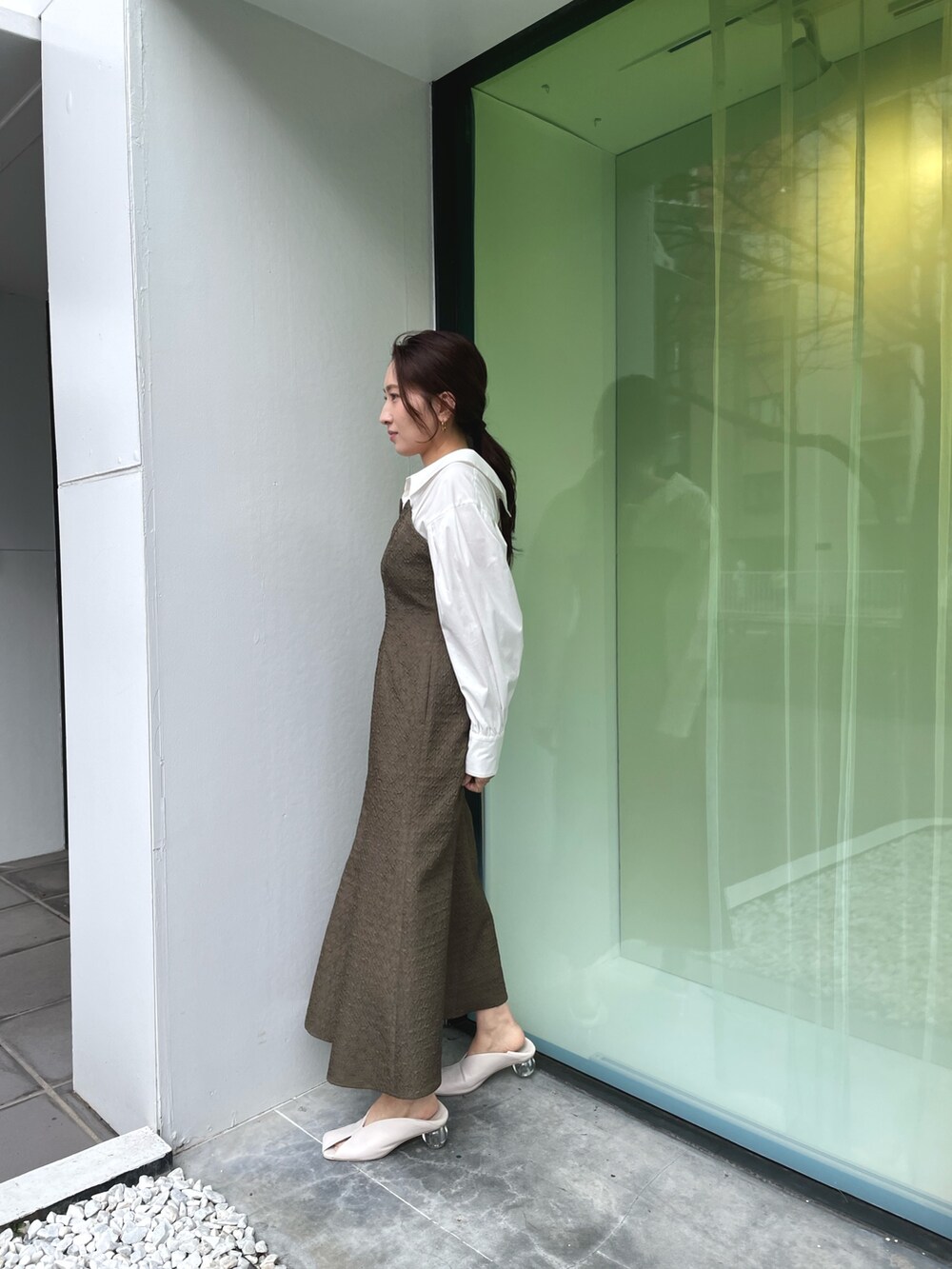 ホワイト系のパンプス、ブラウン系のワンピース、ゴールド系のネックレスを着用したレディースの春コーディネートの4枚目の写真