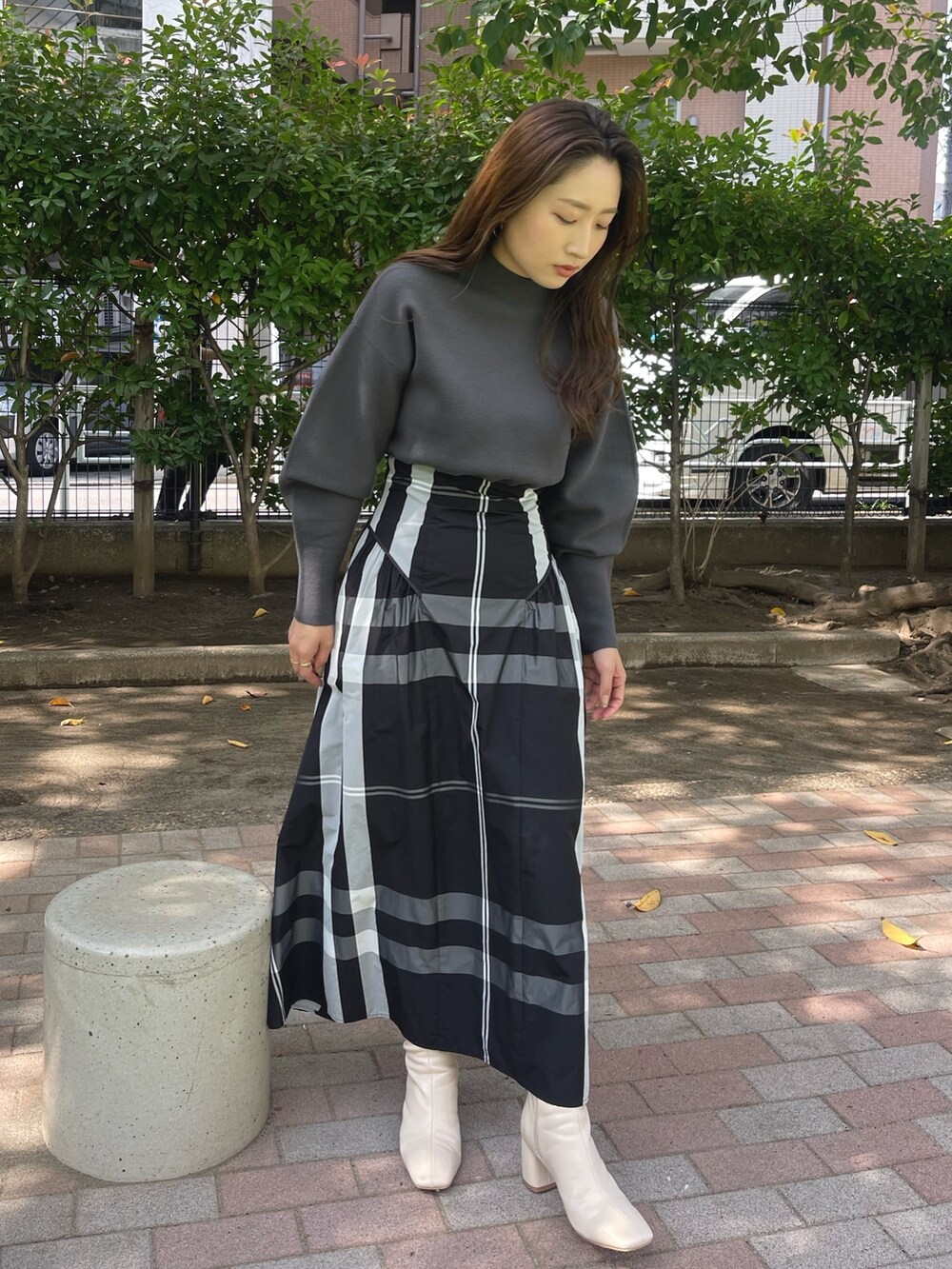 ホワイト系のブーツ、ブラック系のワンピースを着用したレディースの冬コーディネートの2枚目の写真