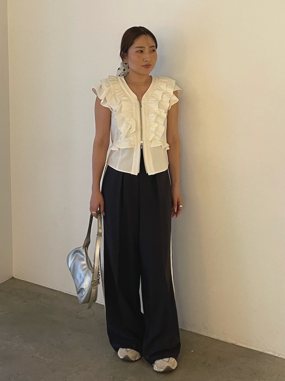 シルバー系のハンドバッグ、ホワイト系のシャツ/ブラウス、グレー系のその他パンツを着用したレディースの春コーディネートの2枚目の写真