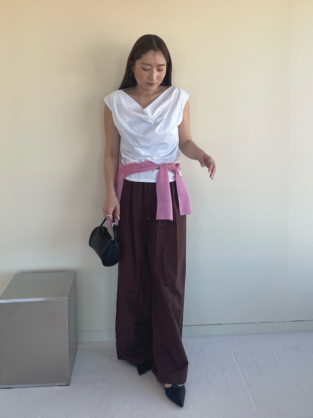 ホワイト系のTシャツ/カットソー、ピンク系のカーディガン/ボレロ、ブラック系のパンプスを着用したレディースの春コーディネートの3枚目の写真