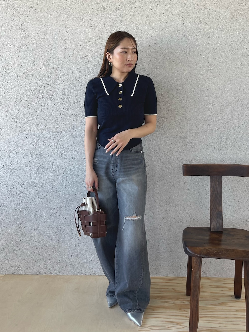 グレー系のデニムパンツ、シルバー系のパンプス、ブルー系のニット/セーターを着用したレディースの春コーディネートの2枚目の写真