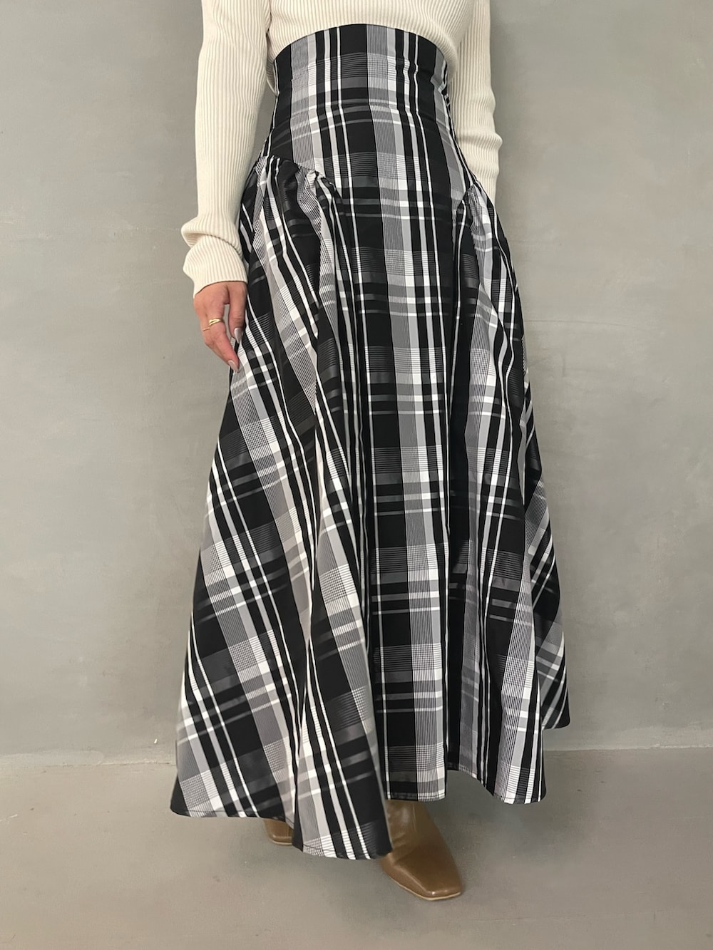 ベージュ系のブーツ、ホワイト系のニット/セーター、ホワイト系のスカートを着用したレディースの秋コーディネートの7枚目の写真