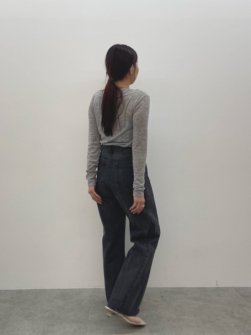 ブラック系のデニムパンツ、ホワイト系のサンダル、グレー系のTシャツ/カットソーを着用したレディースの春コーディネートの4枚目の写真