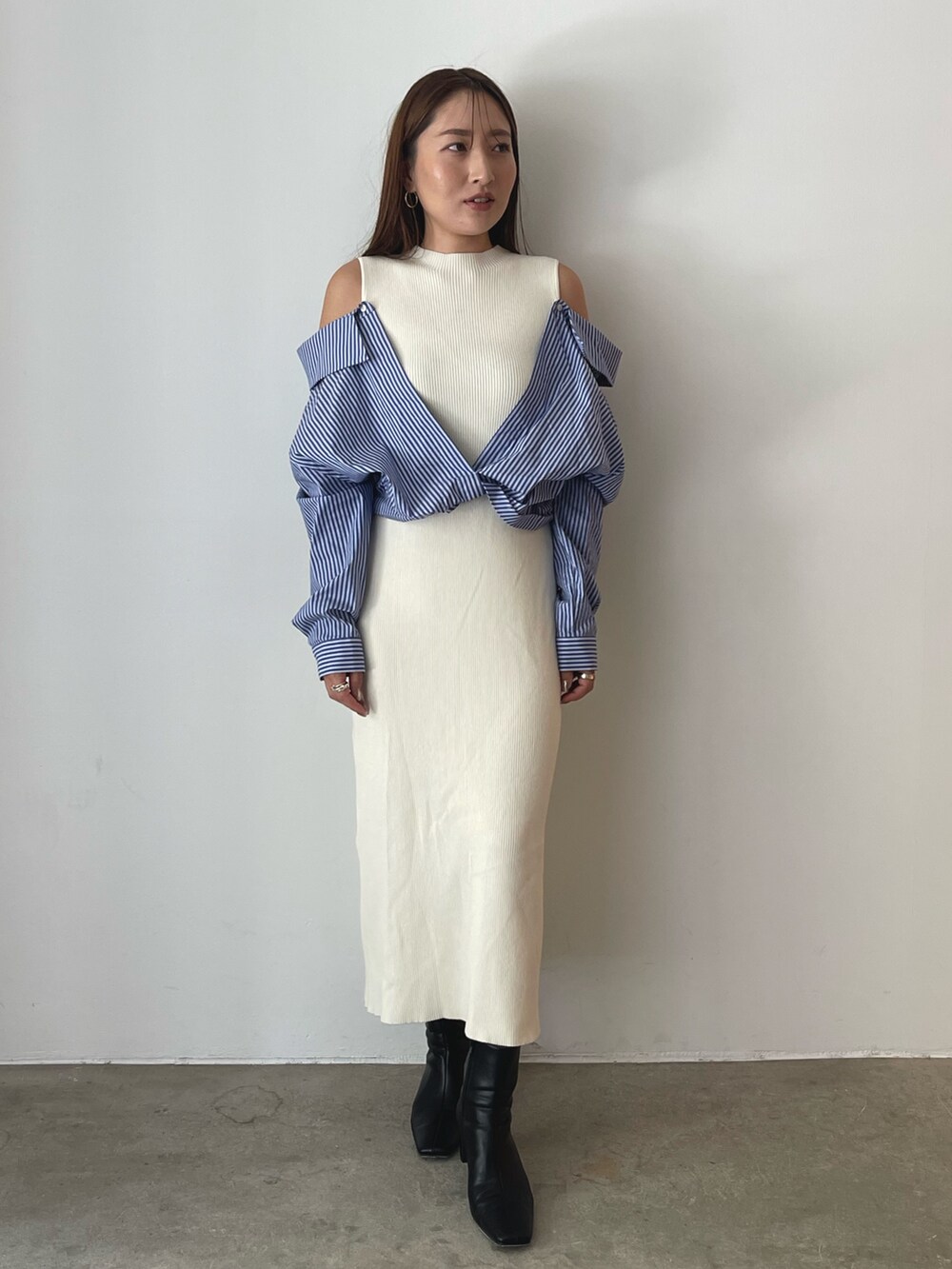 ブラック系のブーツ、ホワイト系のワンピースを着用したレディースの秋コーディネートの2枚目の写真