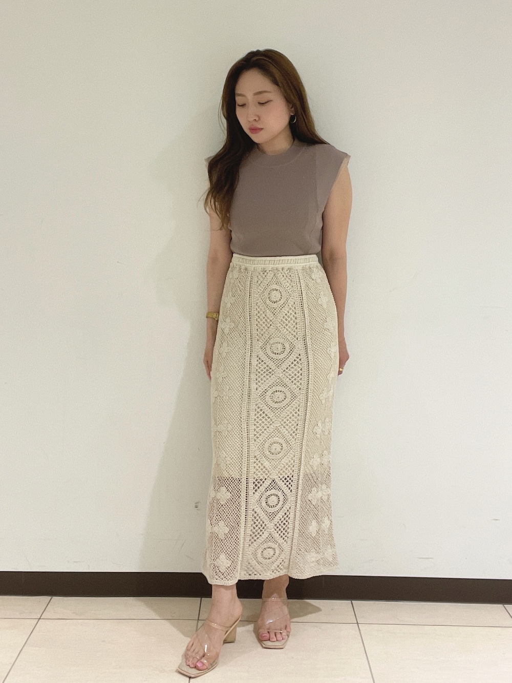 ホワイト系のスカート、ベージュ系のニット/セーターを着用したレディースの夏コーディネートの2枚目の写真