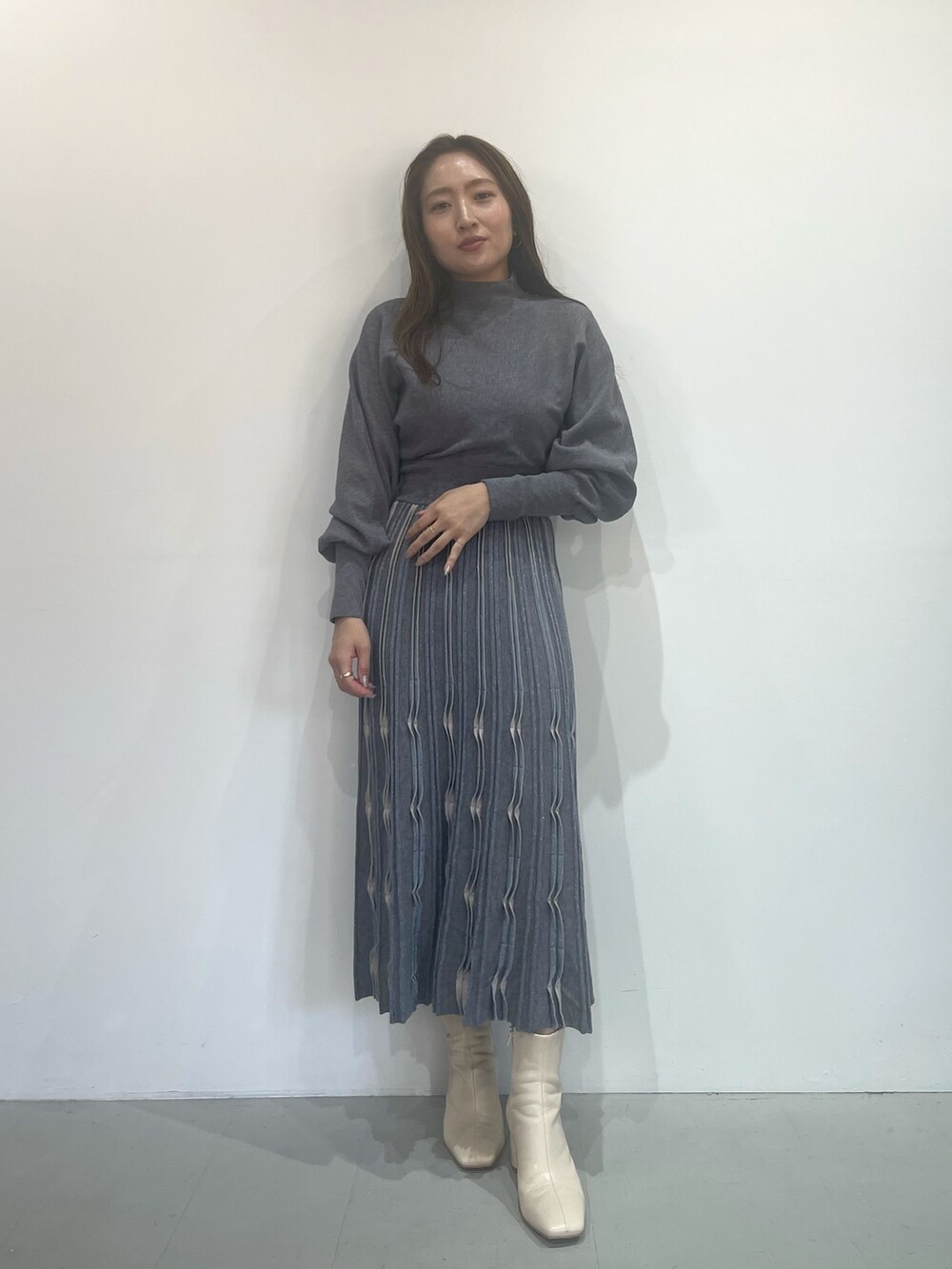 ホワイト系のブーツ、グレー系のワンピースを着用したレディースの秋コーディネートの5枚目の写真