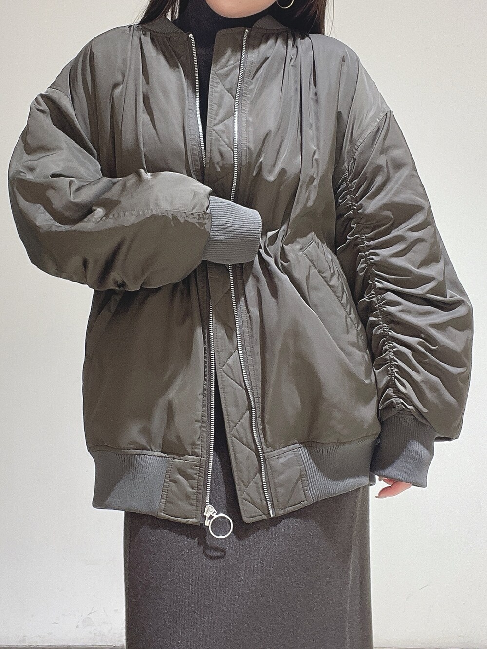 ブラウン系のニット/セーター、ブラウン系のスカート、ブラック系のブーツを着用したレディースの冬コーディネートの10枚目の写真