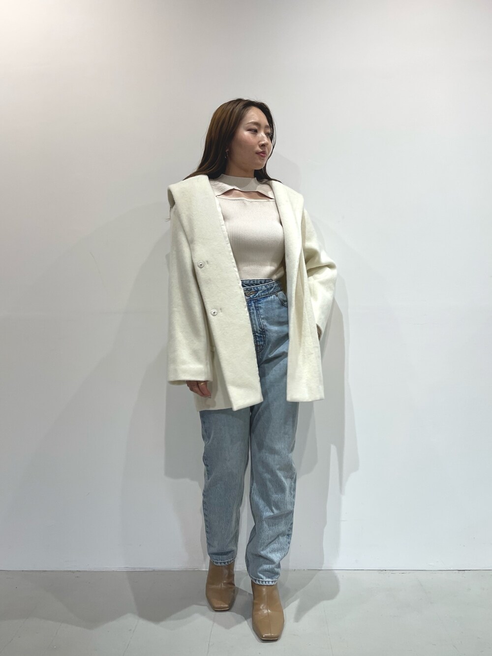 ホワイト系のニット/セーター、ベージュ系のブーツ、ホワイト系のその他アウターを着用したレディースの秋コーディネートの3枚目の写真