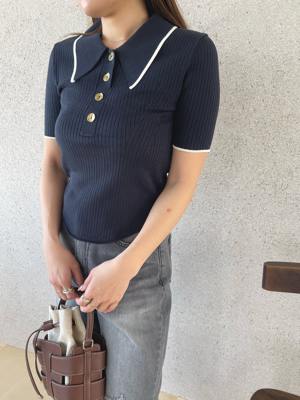 グレー系のデニムパンツ、シルバー系のパンプス、ブルー系のニット/セーターを着用したレディースの春コーディネートの6枚目の写真